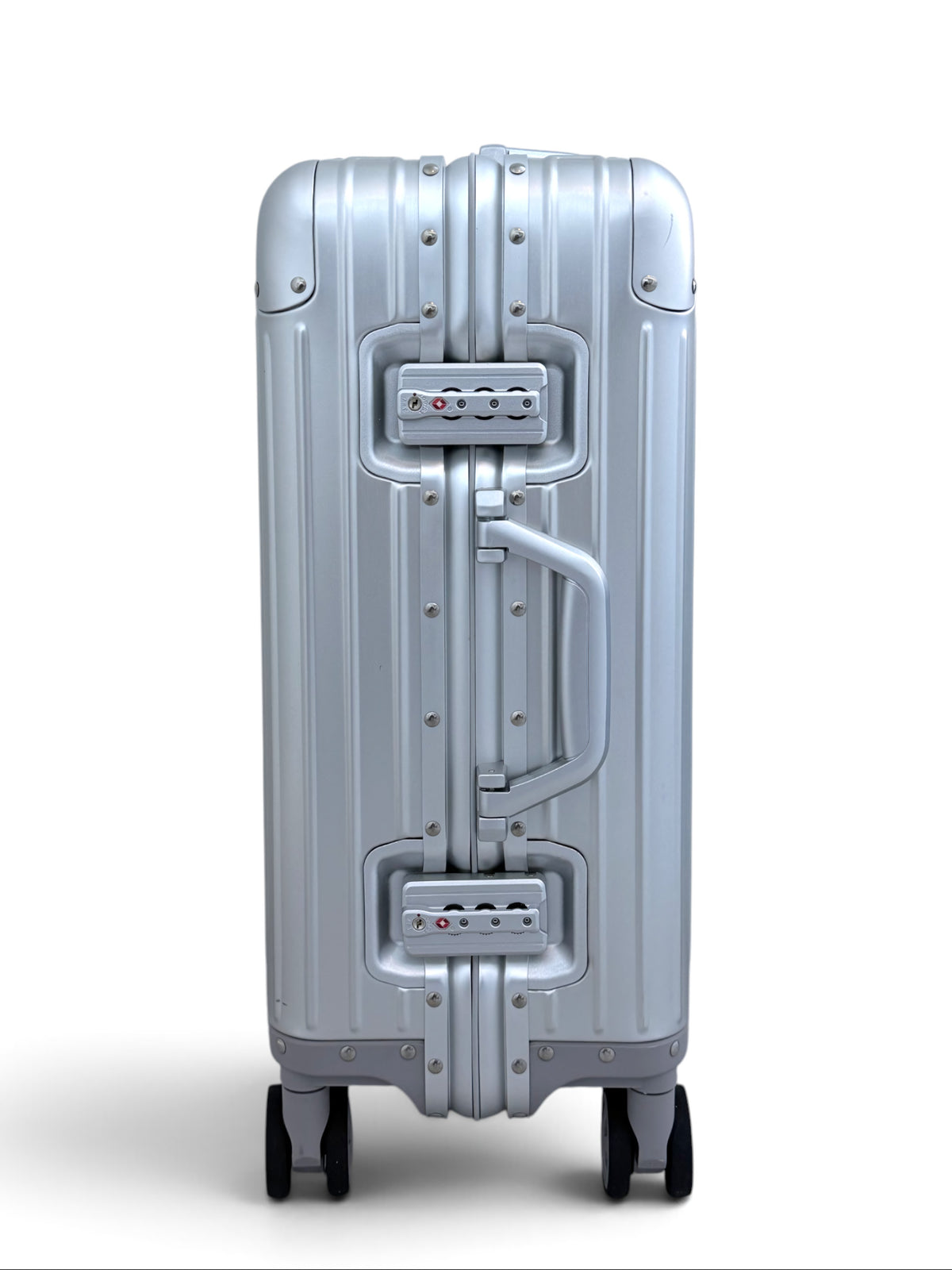 Talo 20-inch carry-on suitcase in silver ribbed aluminum with TSA-approved frame latches and silent spinner wheels.