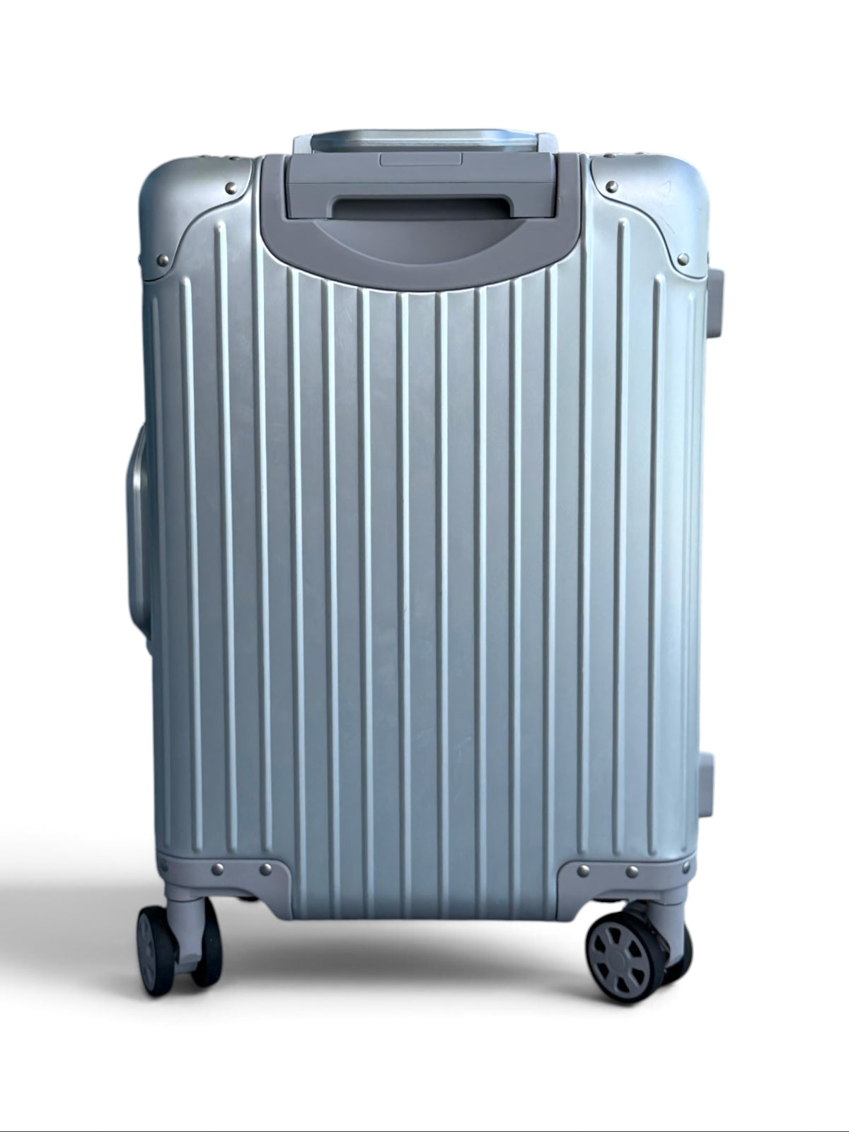 Talo 20-inch carry-on suitcase in silver ribbed aluminum with silent spinner wheels and a machined handle.