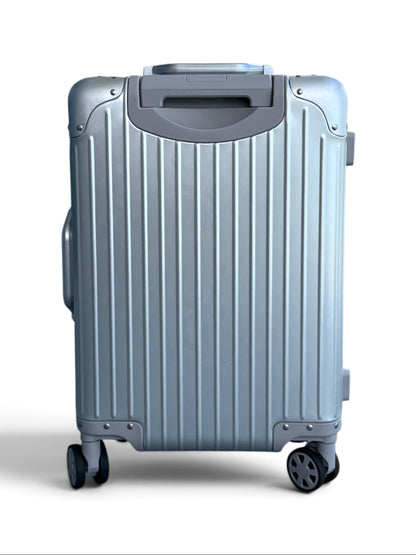 Talo 20-inch carry-on suitcase in silver ribbed aluminum with silent spinner wheels and a machined handle.